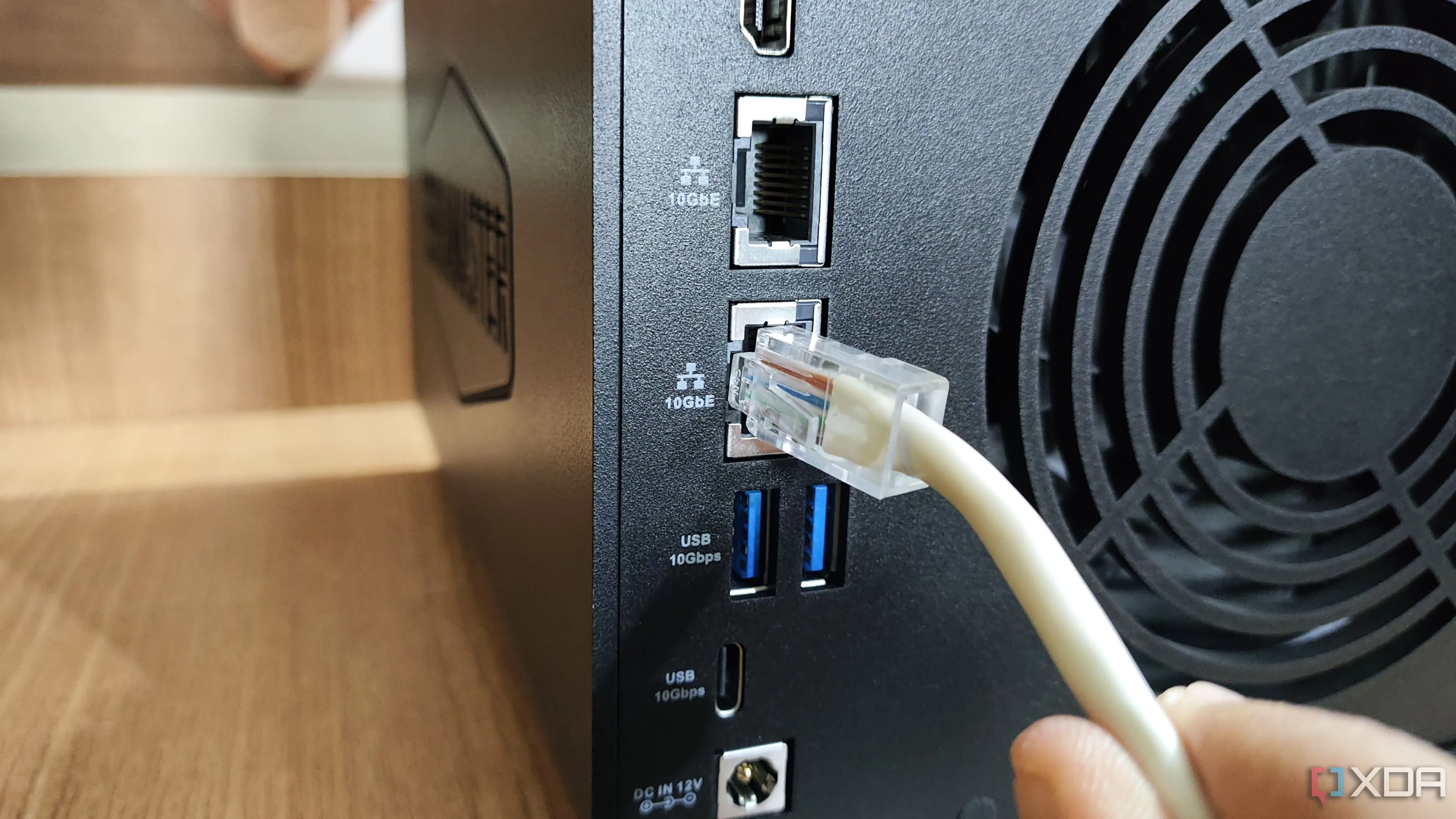 Cắm cáp Ethernet vào cổng LAN trên thiết bị NAS TerraMaster, liên quan đến hoạt động và tiêu thụ điện