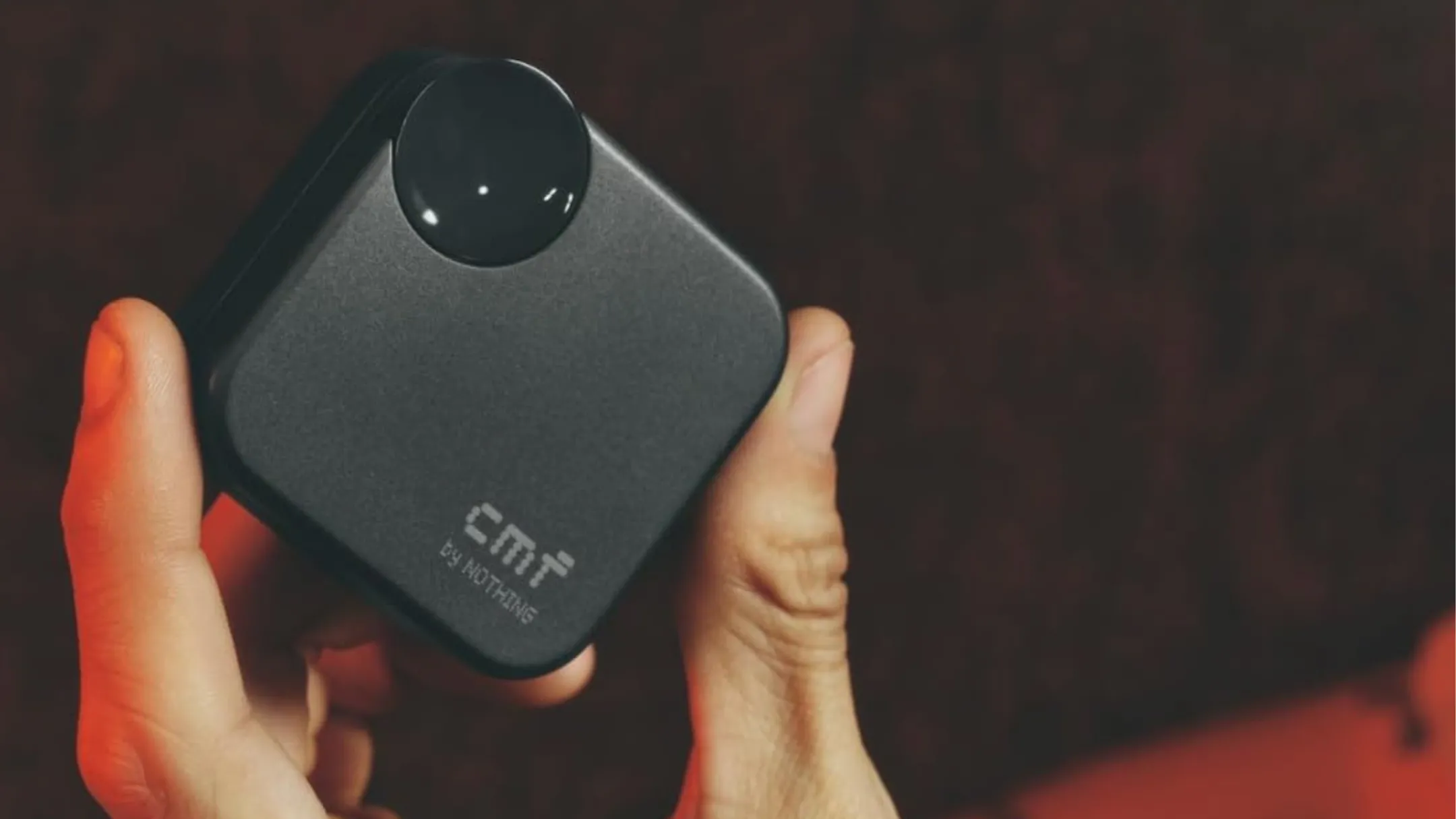 Người đang cầm hộp sạc tai nghe CMF Buds 2a