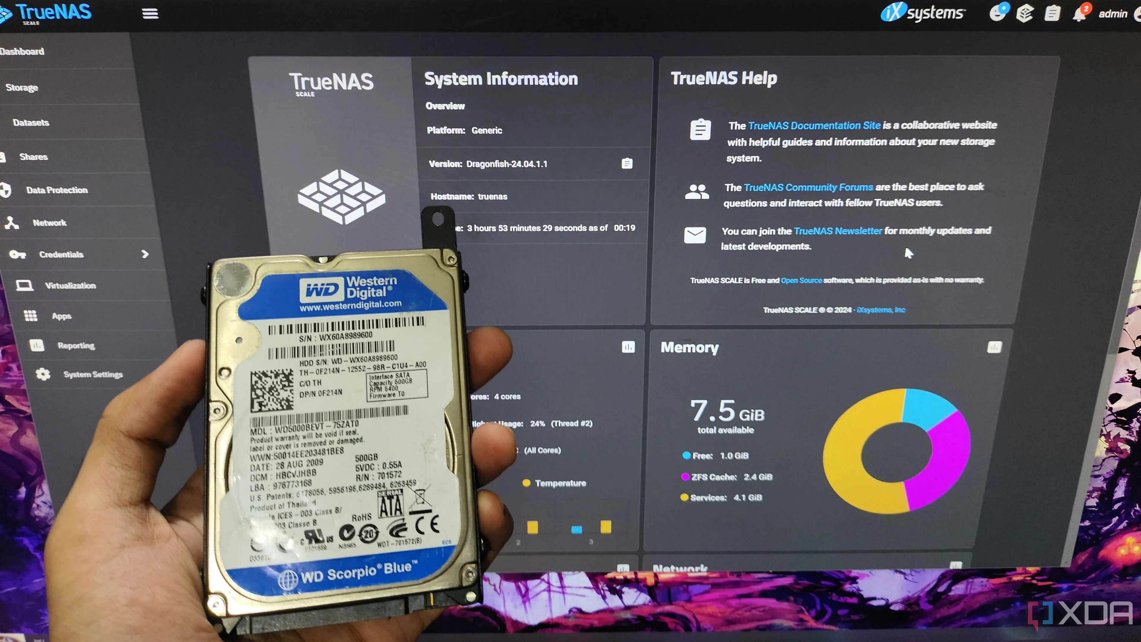 Người dùng cầm ổ cứng HDD trước giao diện quản lý TrueNAS, minh họa việc cấu hình NAS.