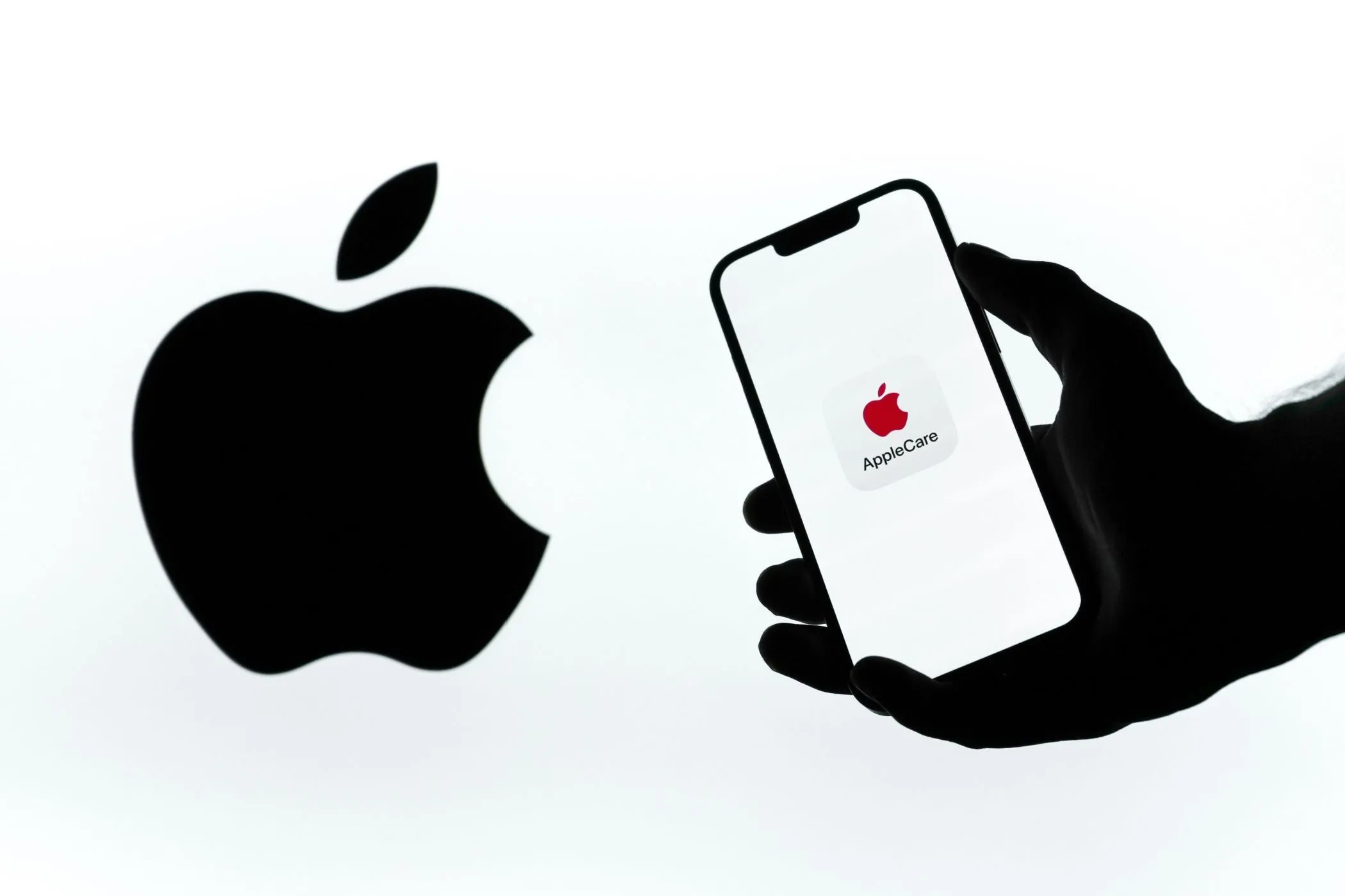 Biểu tượng AppleCare+ trên màn hình điện thoại iPhone cạnh logo Apple, minh họa cho dịch vụ bảo hành truyền thống.