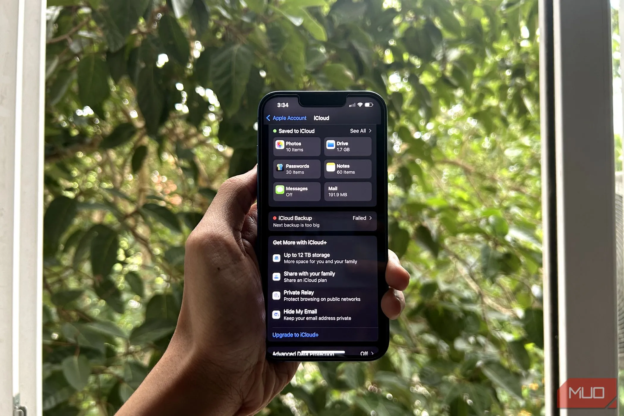 một bàn tay đang cầm iPhone với menu iCloud đang mở