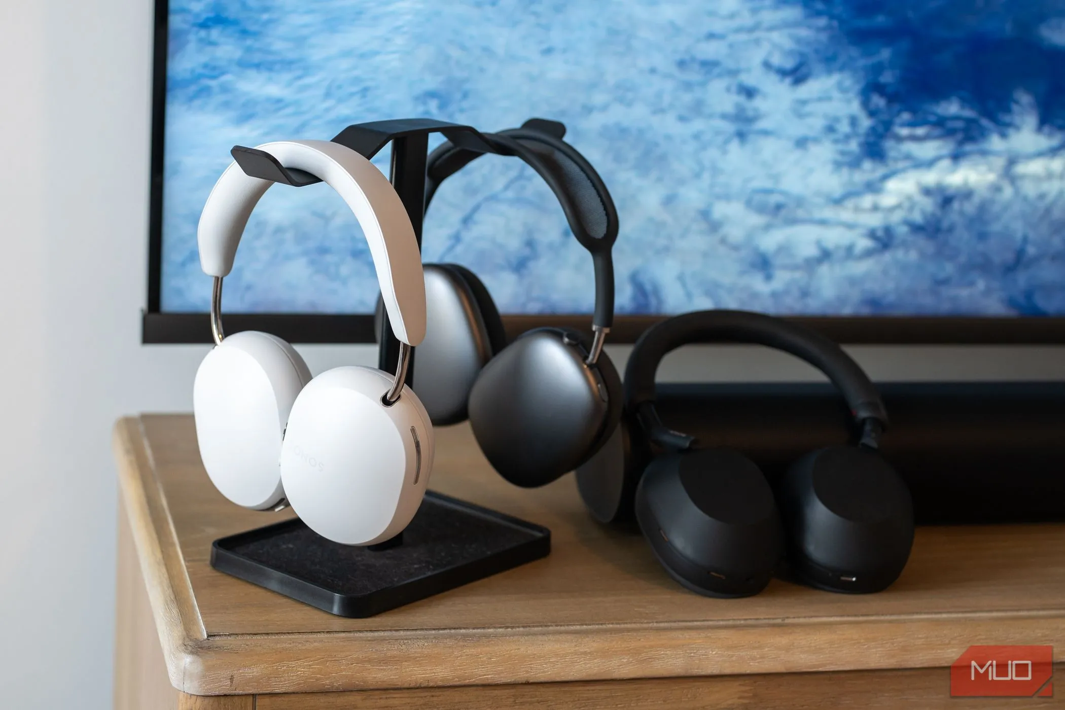 Ba chiếc tai nghe cao cấp Sonos Ace, Apple AirPods Max và Sony WH-1000XM5 đặt cạnh nhau trên giá đỡ tai nghe.