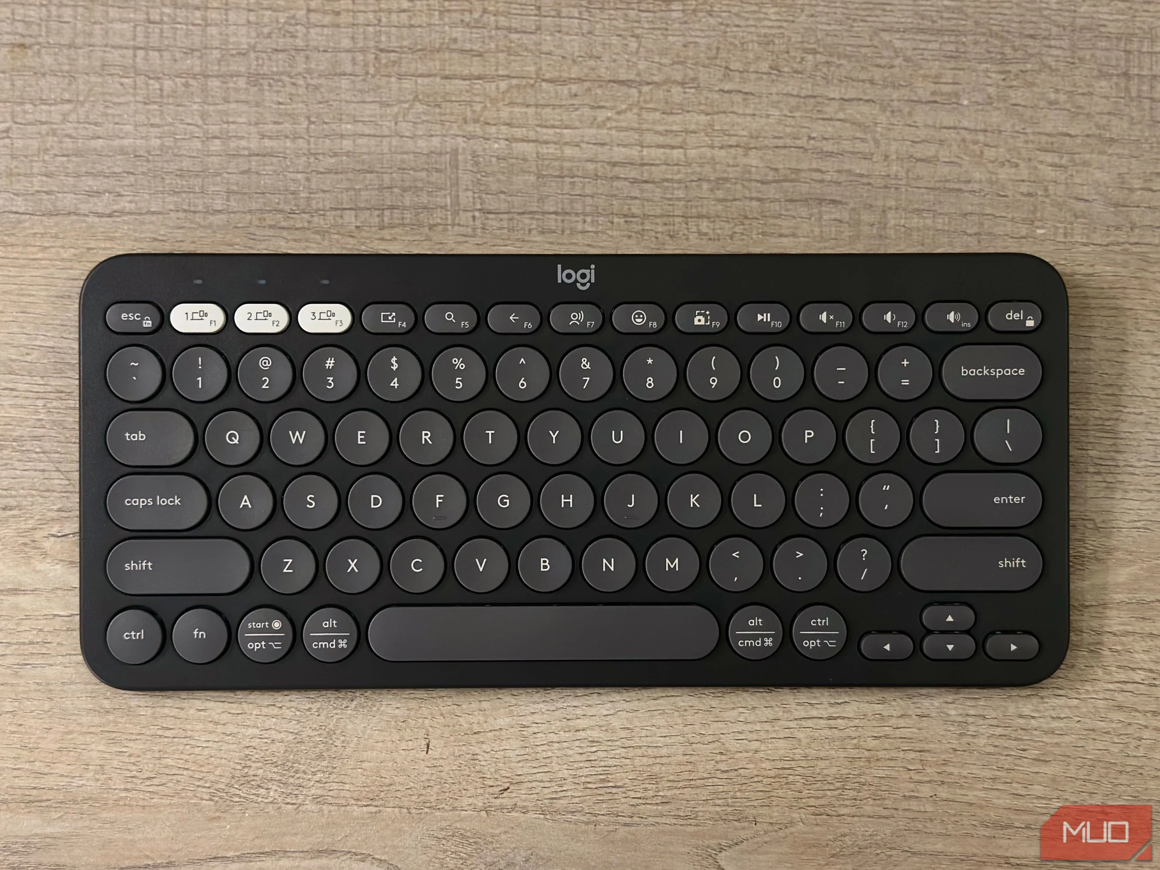 Bàn phím Logitech Pebble Keys 2 K380s màu trắng trên mặt bàn, minh họa phụ kiện cần thiết cho iPad khi làm việc