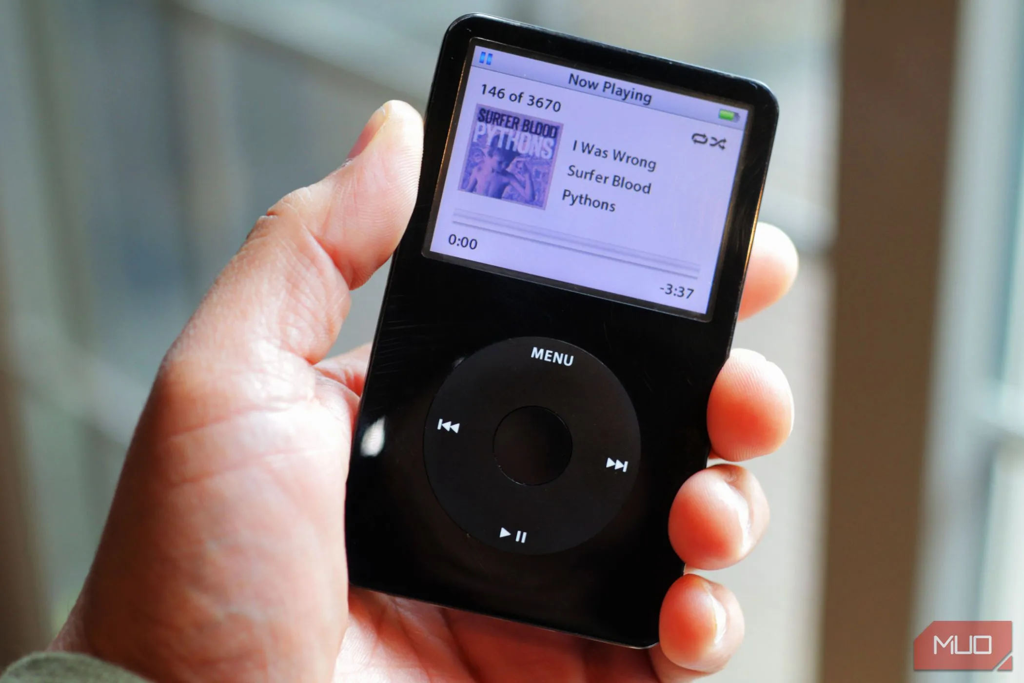 Chiếc iPod Classic màu đen trong tay, gợi nhớ kỷ nguyên máy nghe nhạc MP3 chuyên dụng trước khi smartphone lên ngôi.