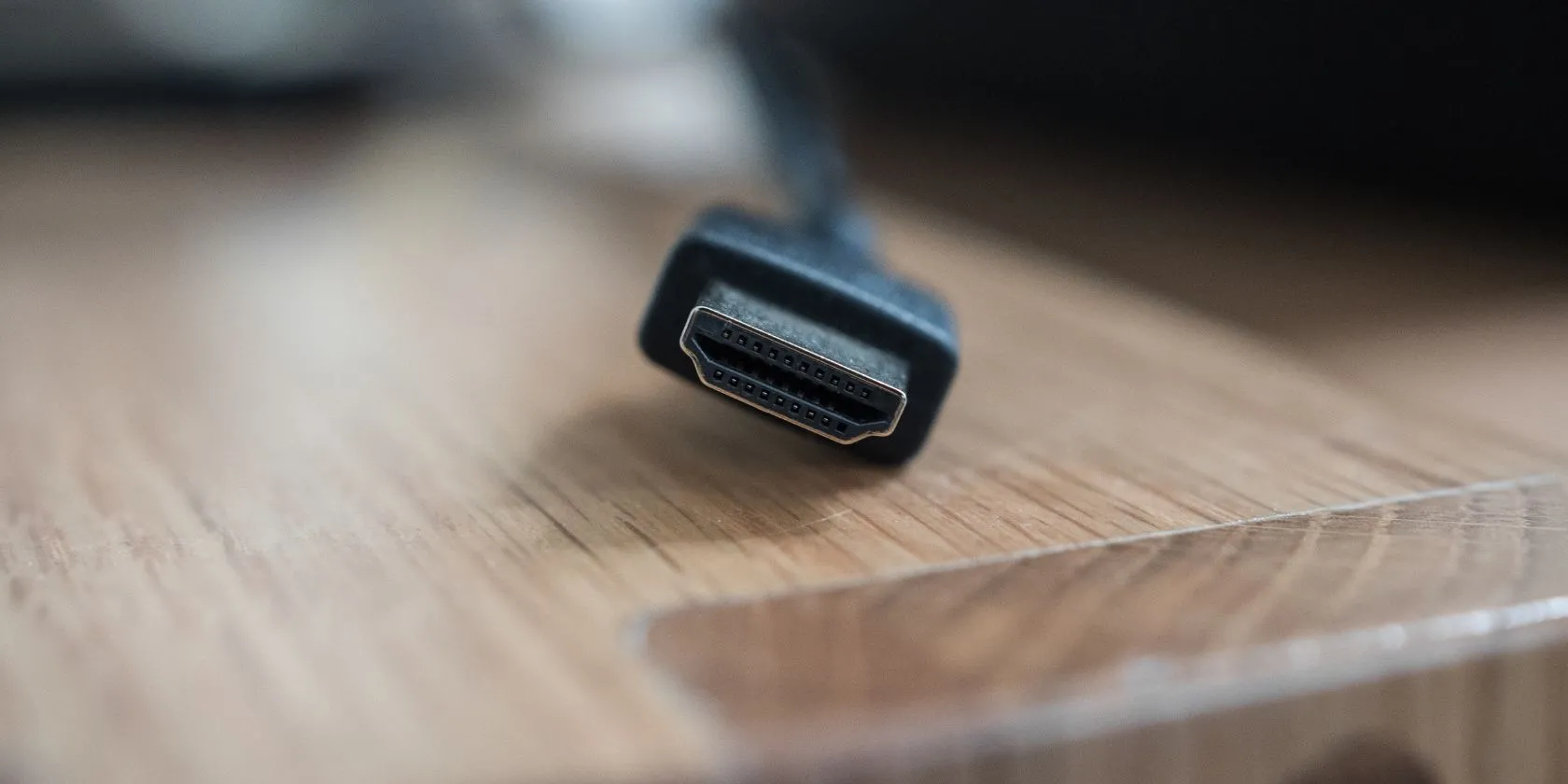 Đầu nối cáp HDMI tiêu chuẩn đặt trên bàn, biểu tượng cho kết nối phổ biến nhất dành cho TV, hệ thống âm thanh và các thiết bị giải trí tại gia, nhấn mạnh vai trò của cáp HDMI chất lượng trong việc truyền tải tín hiệu 4K HDR.