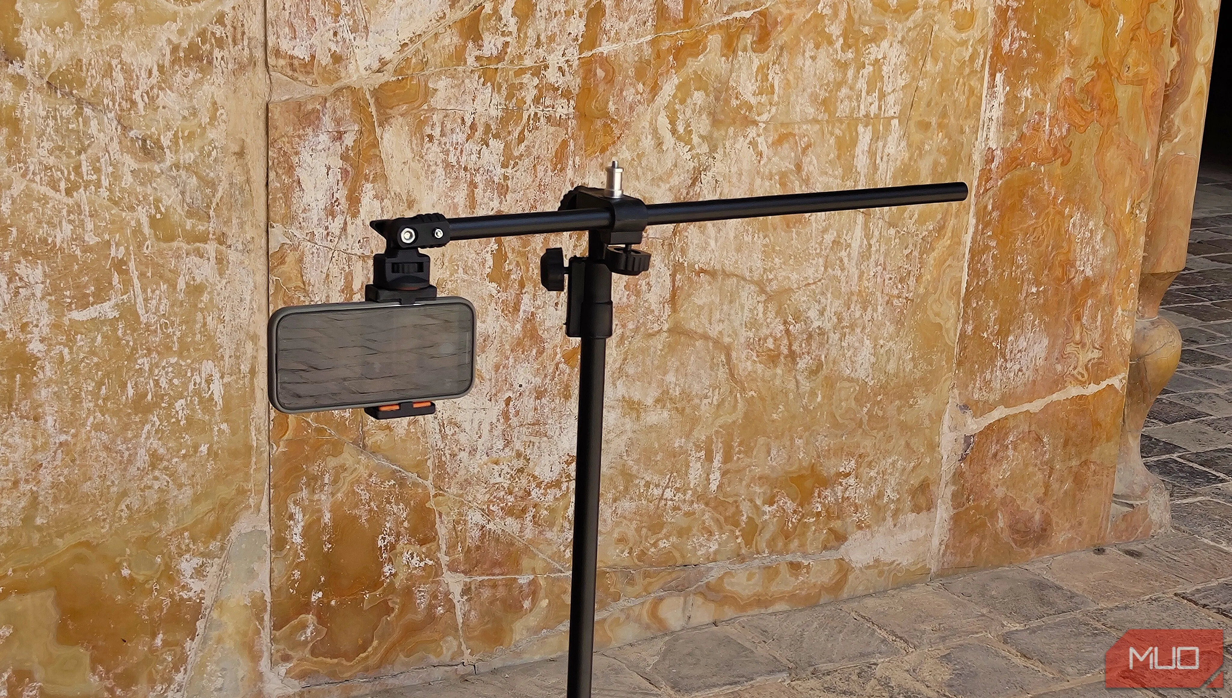Điện thoại gắn trên tripod hướng vào bức tường, thử nghiệm chụp ảnh panorama dọc