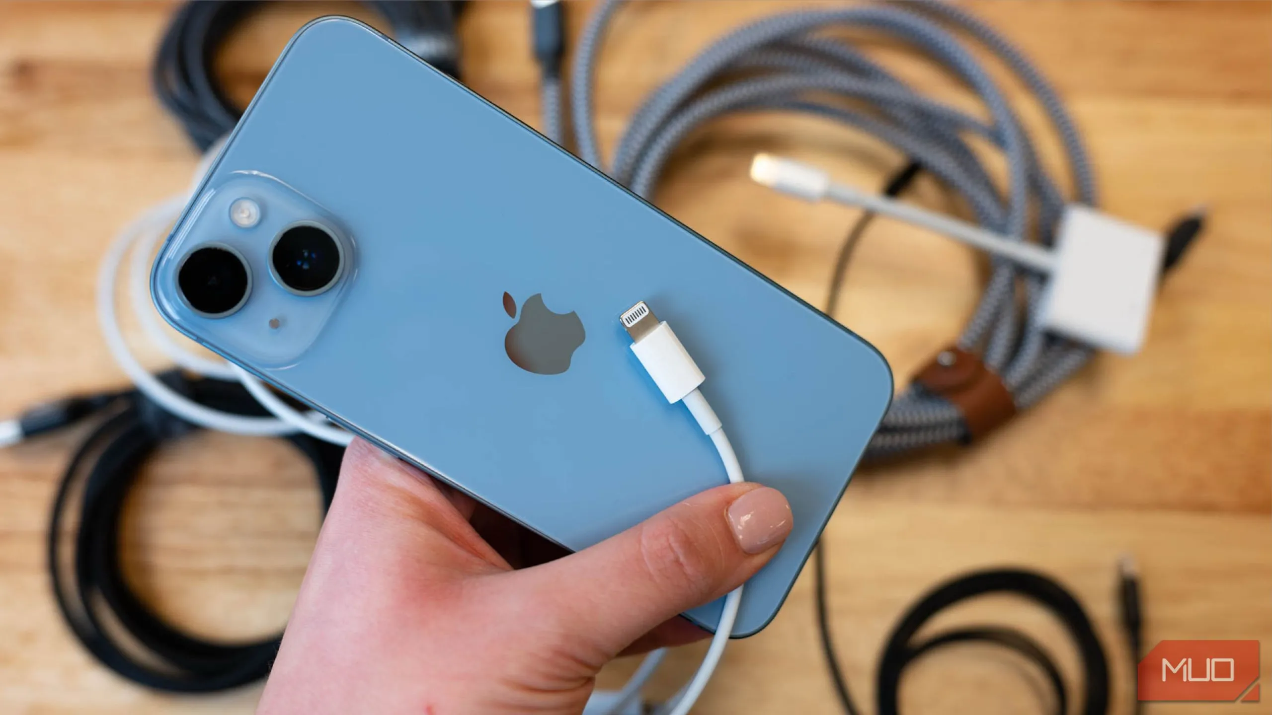 Điện thoại iPhone 13 với cáp sạc Lightning, tượng trưng cho thói quen sạc pin nhanh gọn trong thời gian ngắn thay vì sạc qua đêm.