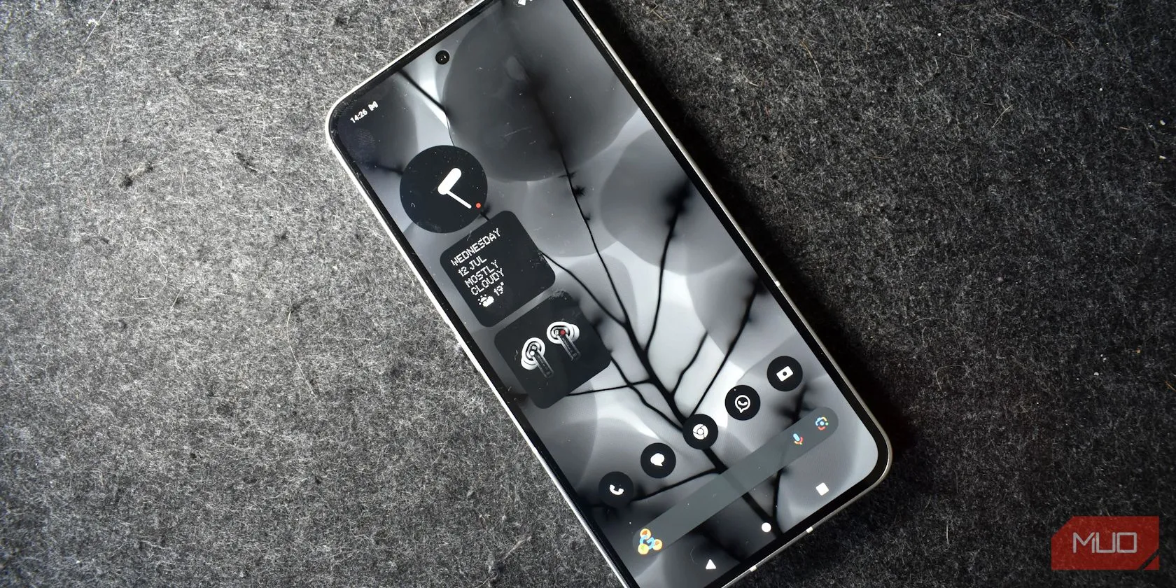 Điện thoại Nothing Phone 2 nhìn từ trên xuống, màn hình đang bật, thể hiện khả năng chống bám vân tay và bề mặt sạch.