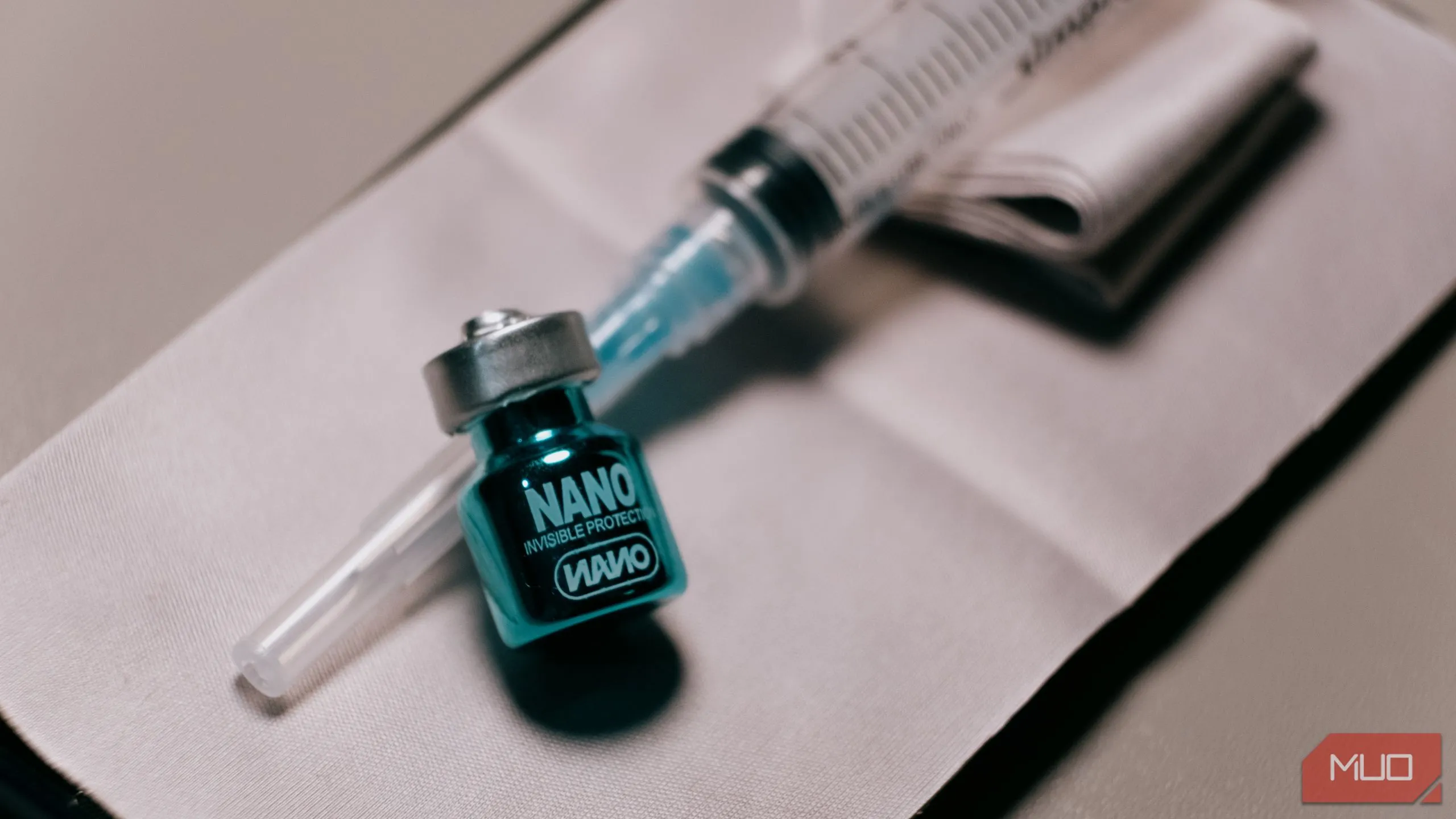 Dung dịch phủ nano oleophobic dạng lỏng bên cạnh ống tiêm nhỏ giọt, chuẩn bị cho quá trình thử nghiệm