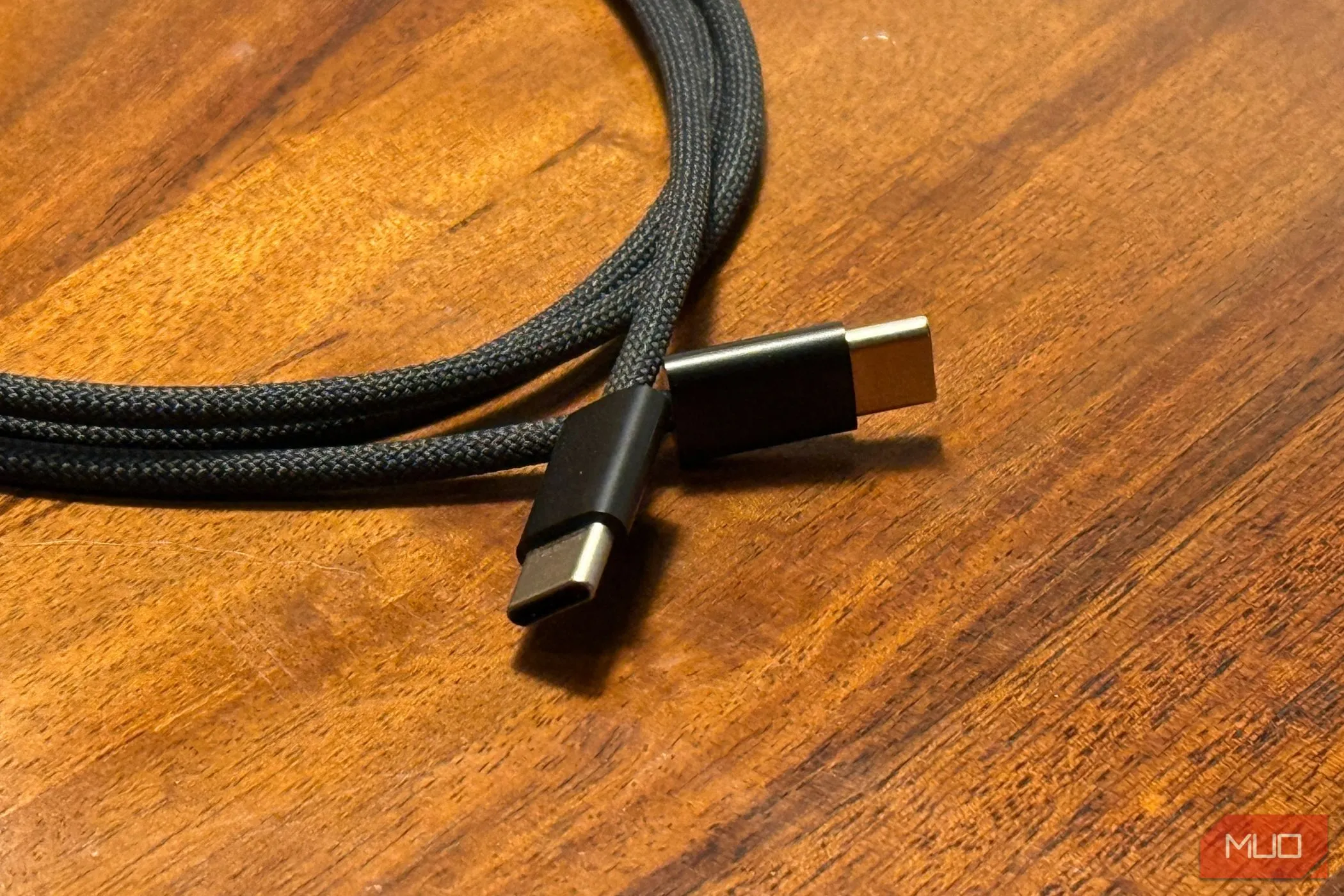 Hai đầu cáp sạc USB-C sang USB-C đặt trên bàn gỗ, minh họa loại cáp sạc đa năng cho iPhone