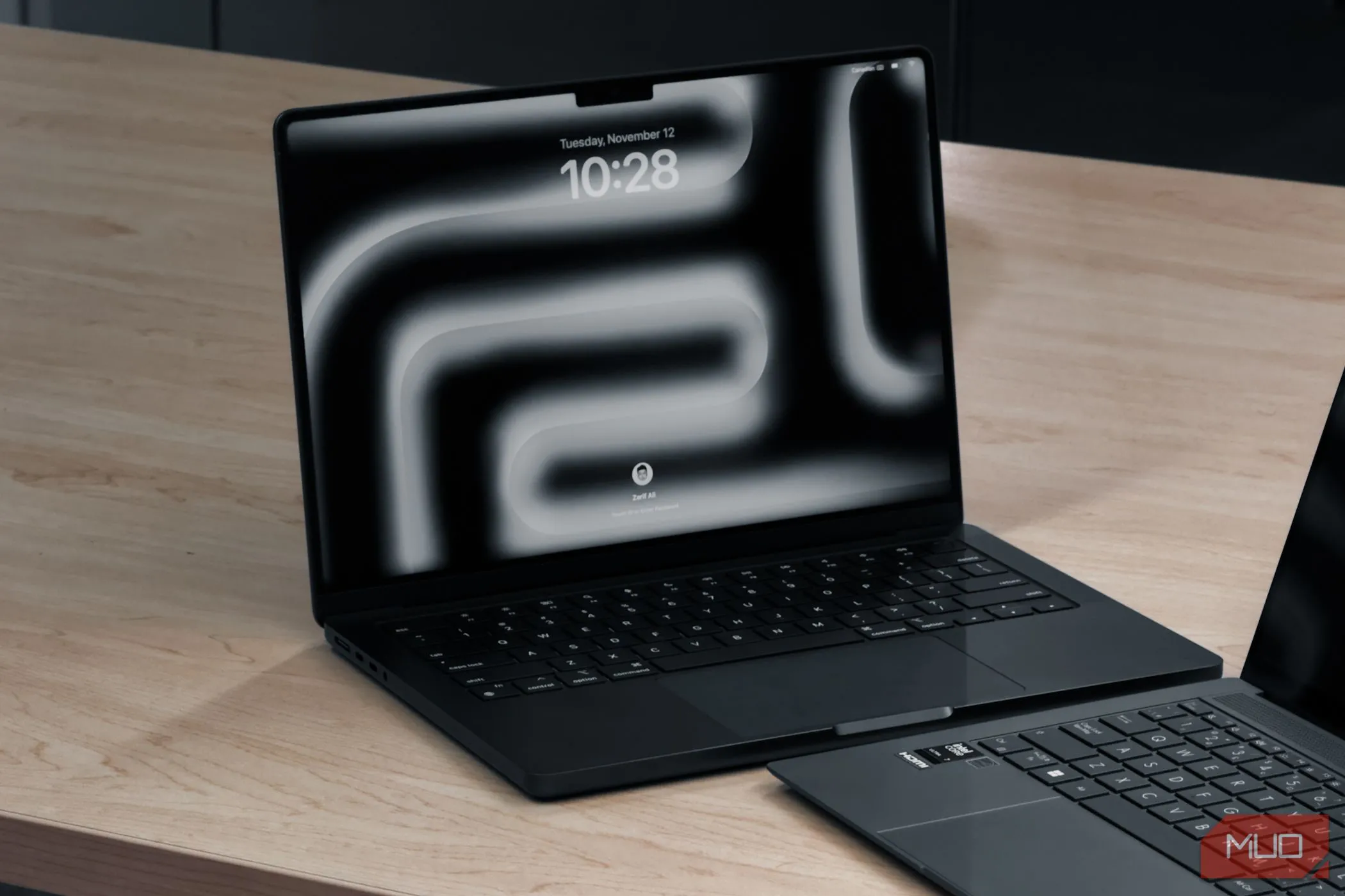 Hai laptop, một chiếc MacBook Pro M4 và một chiếc khác, đặt trên bàn gỗ