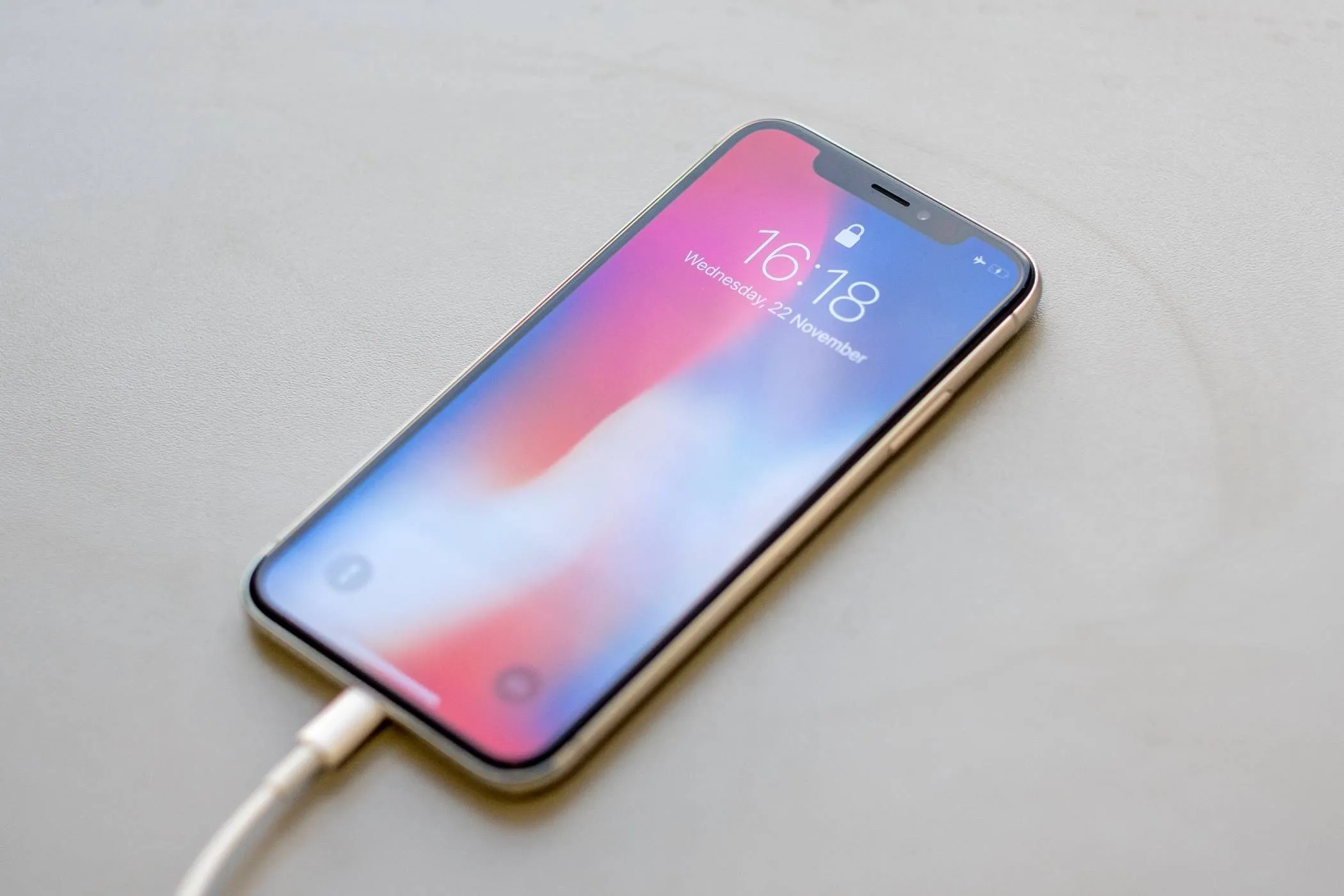 Hình ảnh iPhone đang được cắm vào cáp sạc, minh họa cho lầm tưởng phổ biến về việc không nên sạc pin iPhone qua đêm.
