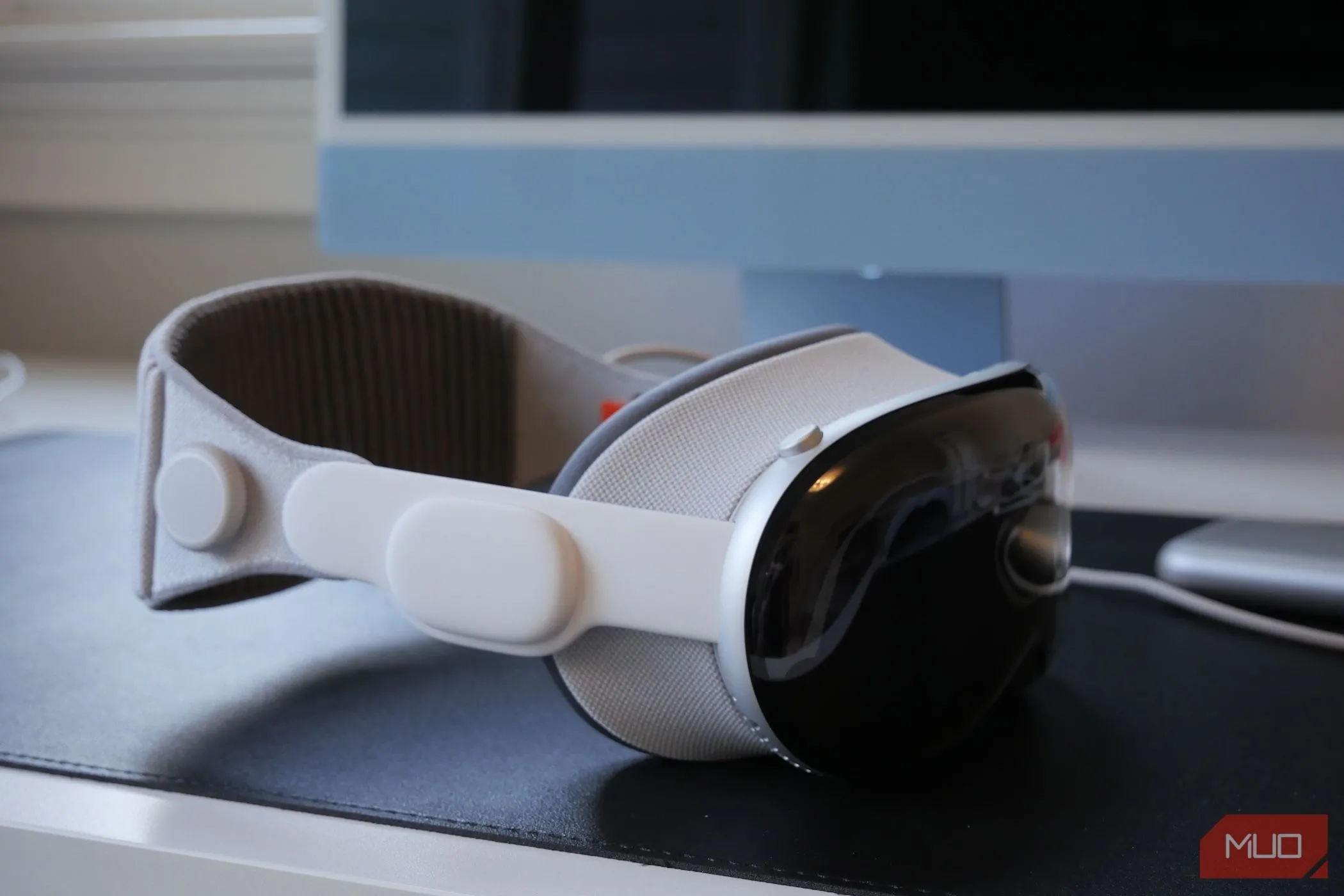 Kính thực tế hỗn hợp Apple Vision Pro đặt trên bàn làm việc, gợi mở khả năng tạo không gian làm việc ảo khi kết nối với iPhone.