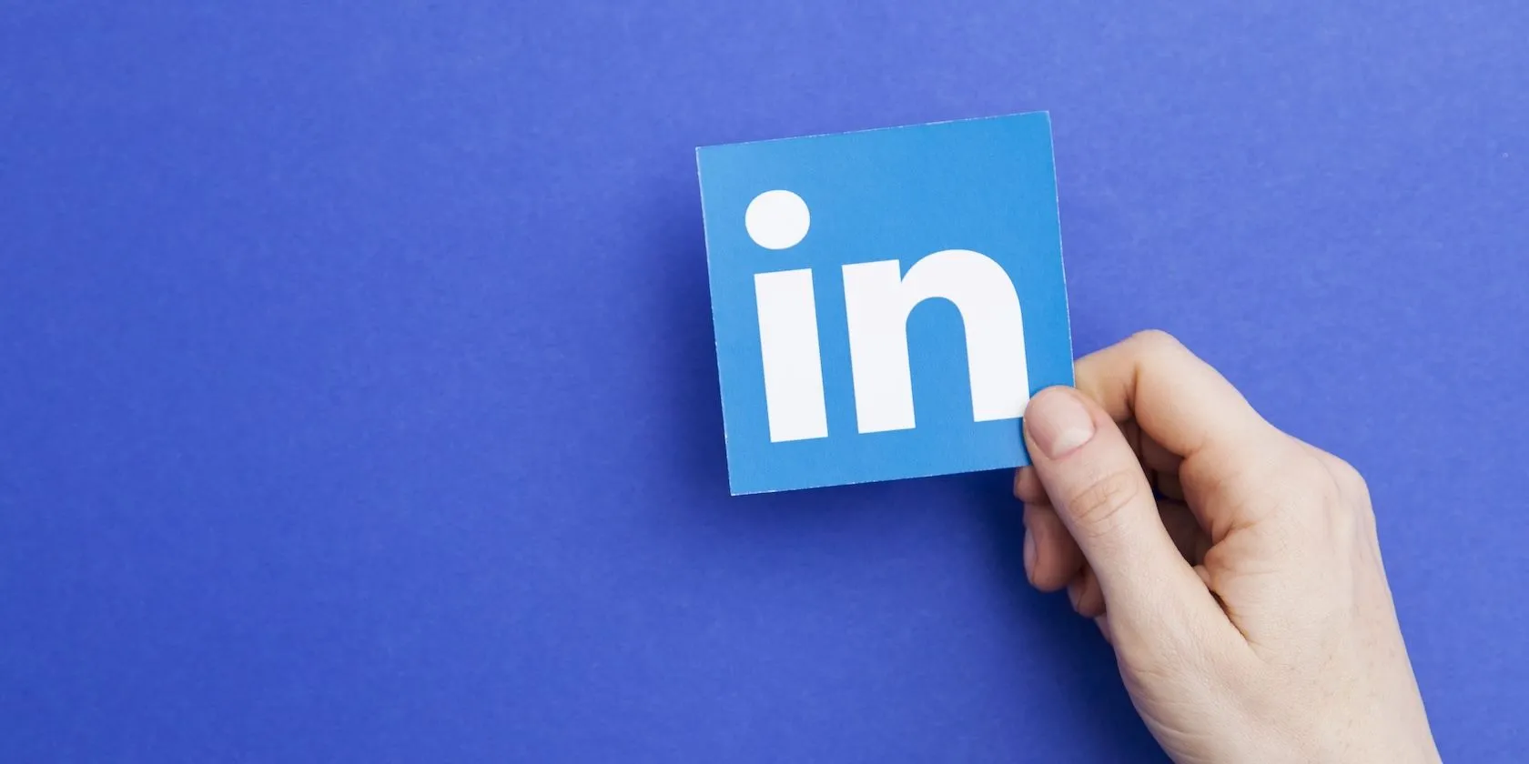 Logo LinkedIn được giữ trên tay, minh họa cho mạng xã hội chuyên nghiệp này, nơi thu thập và chia sẻ một lượng lớn thông tin người dùng cho mục đích đào tạo AI.