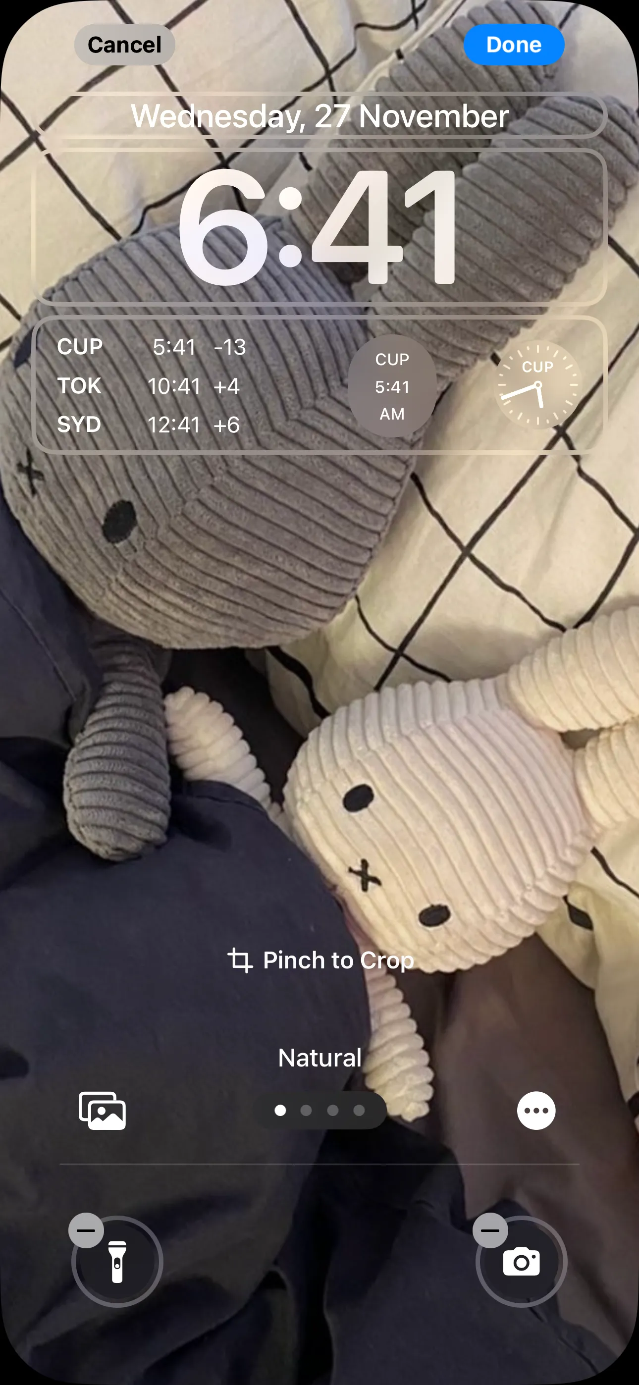 Màn hình khóa iPhone với các widget đồng hồ múi giờ đã được thêm.