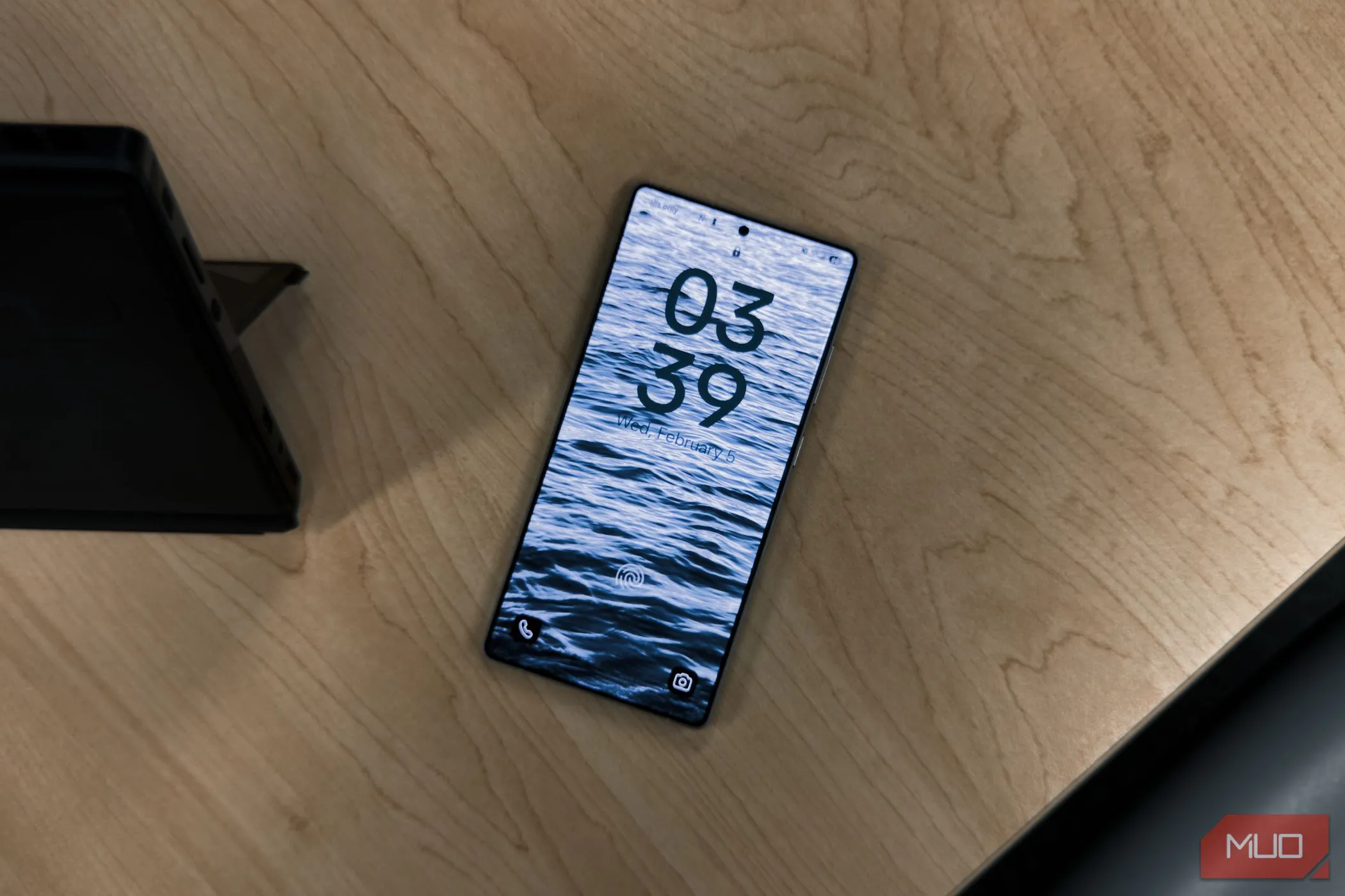 Màn hình khóa Samsung Galaxy S25 Ultra hiển thị đồng hồ trên bàn gỗ