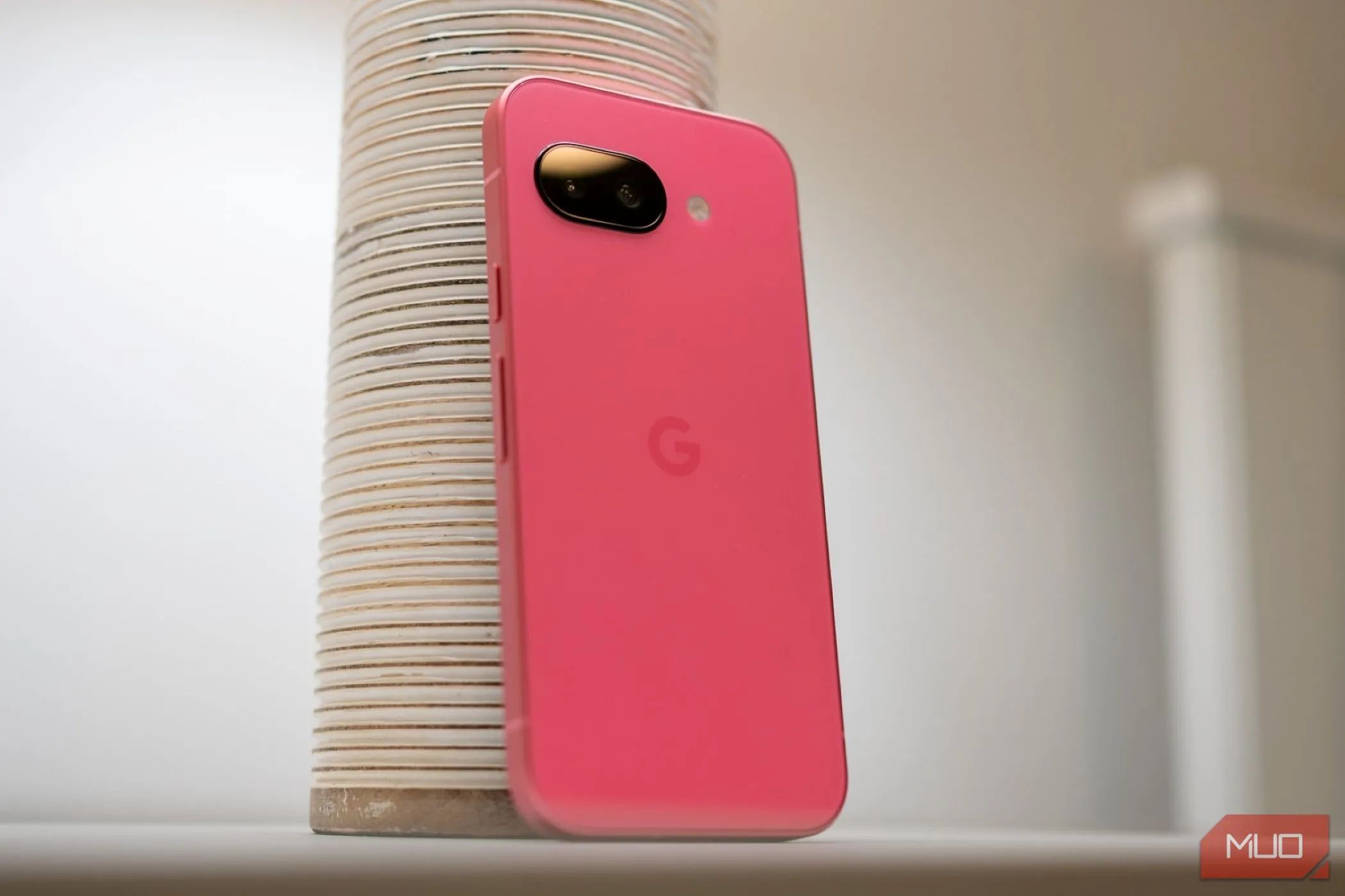 Mặt lưng của điện thoại Google Pixel 9a màu đen đặt trên mặt bàn, thể hiện thiết kế tổng thể của chiếc smartphone tầm trung này.