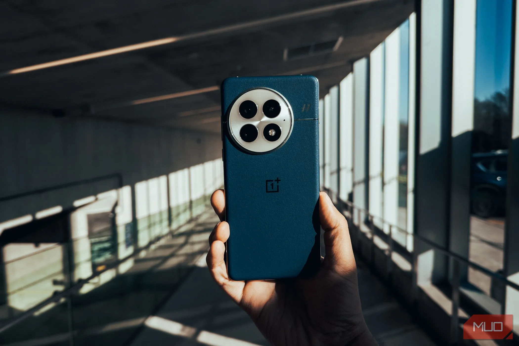 Mặt lưng của OnePlus 13 với lớp hoàn thiện màu đen, nổi bật trên phông nền đô thị, tượng trưng cho hiệu năng mạnh mẽ