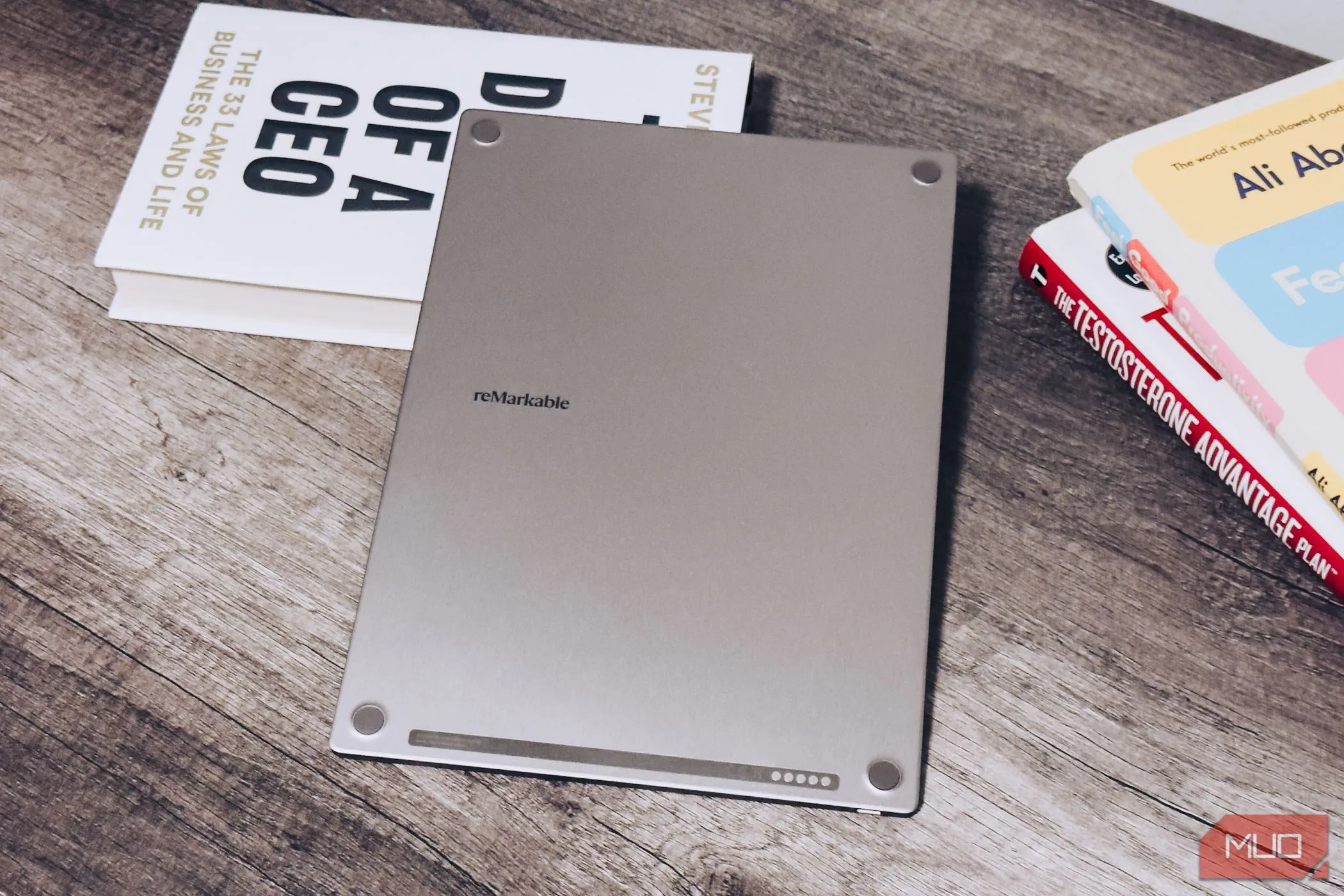 Mặt lưng của reMarkable Paper Pro đặt trên bàn gỗ cạnh sách, tổng kết thiết kế và cảm giác sang trọng của thiết bị, nhấn mạnh sự kết nối giữa analog và kỹ thuật số.