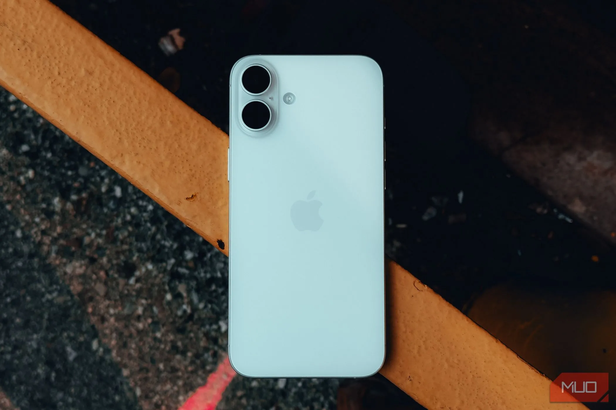Mặt lưng iPhone 16 Plus đặt trên lan can, minh họa vị trí chạm để kích hoạt Back Tap