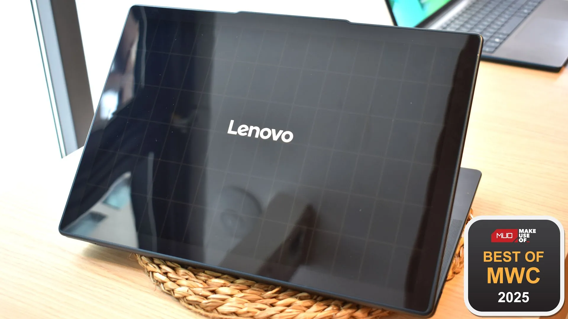 Mặt sau của laptop Lenovo Yoga Solar PC với tấm pin năng lượng mặt trời và biểu tượng giải thưởng tại MWC 2025.