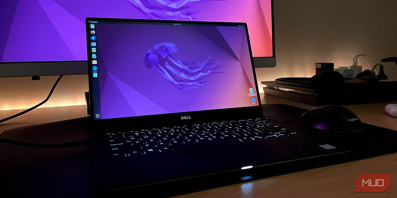 Máy tính Dell XPS 13 hiển thị giao diện Ubuntu, phía sau là màn hình rời