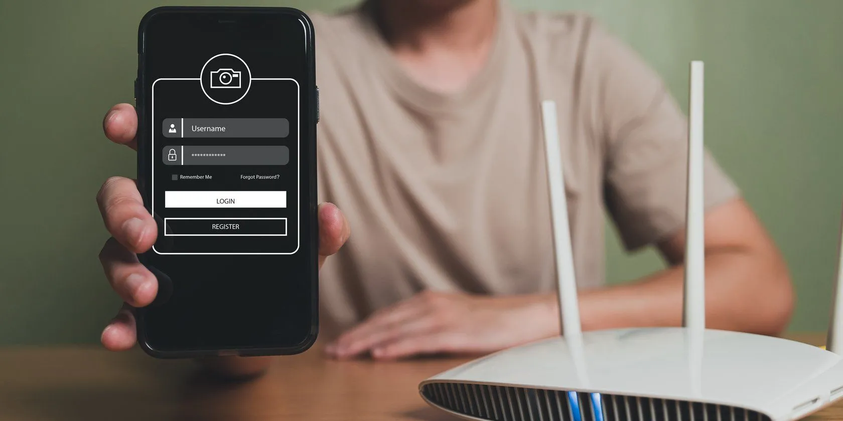 Người đàn ông cầm điện thoại cạnh router Wi-Fi đang phát sóng