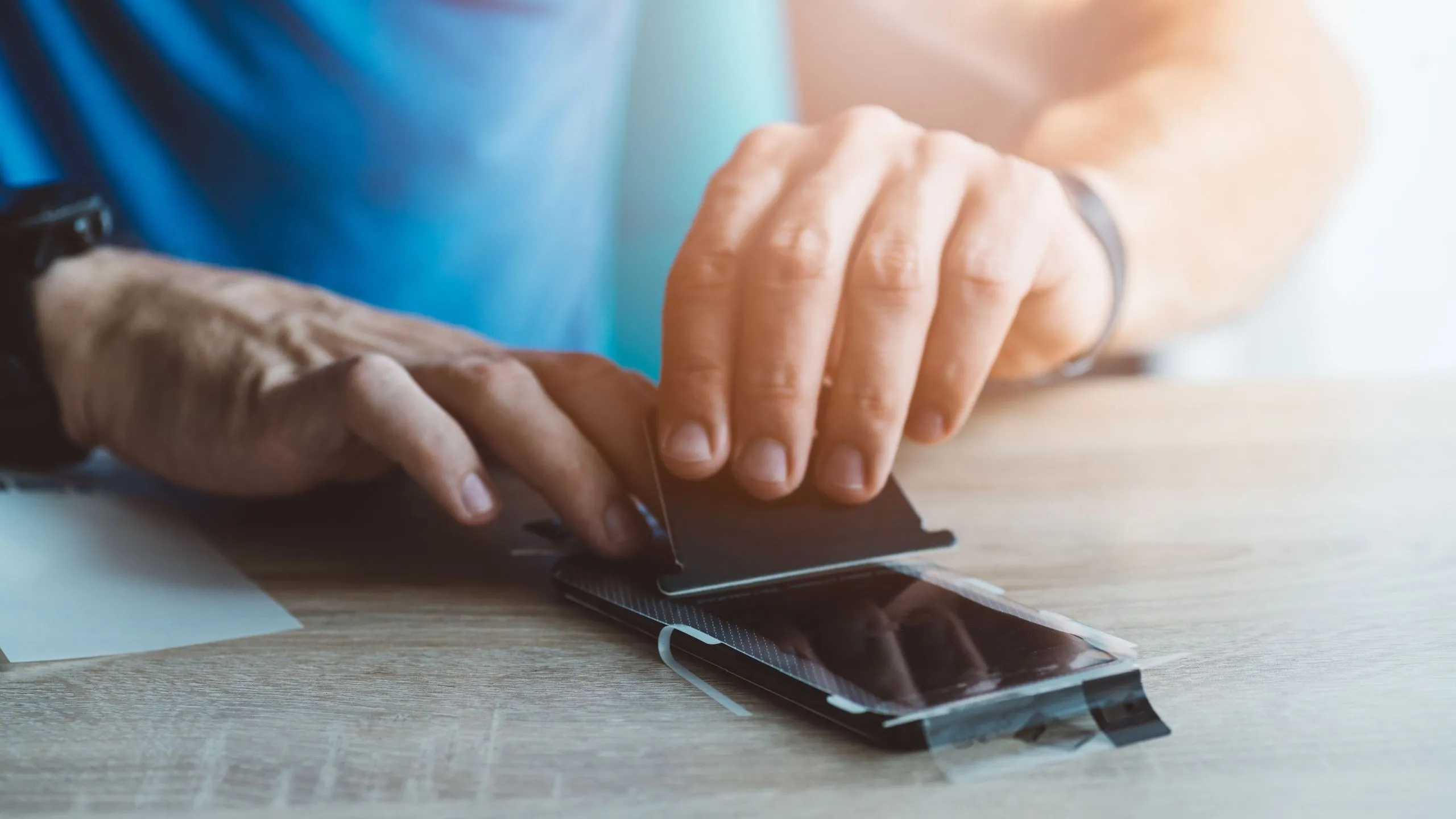 Người đàn ông dán miếng dán bảo vệ lên điện thoại iPhone