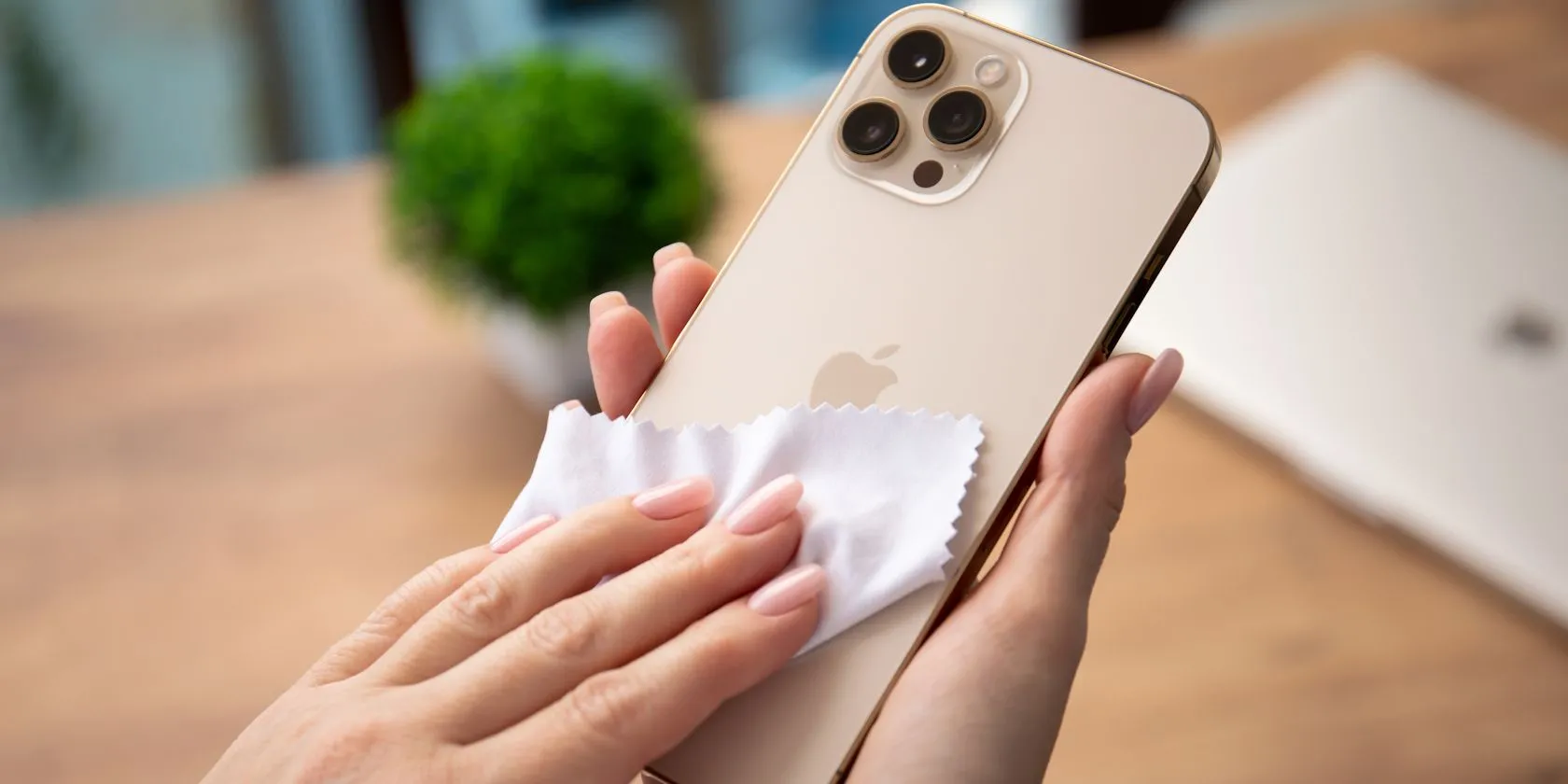 Người phụ nữ đang lau màn hình iPhone bằng khăn vải microfiber