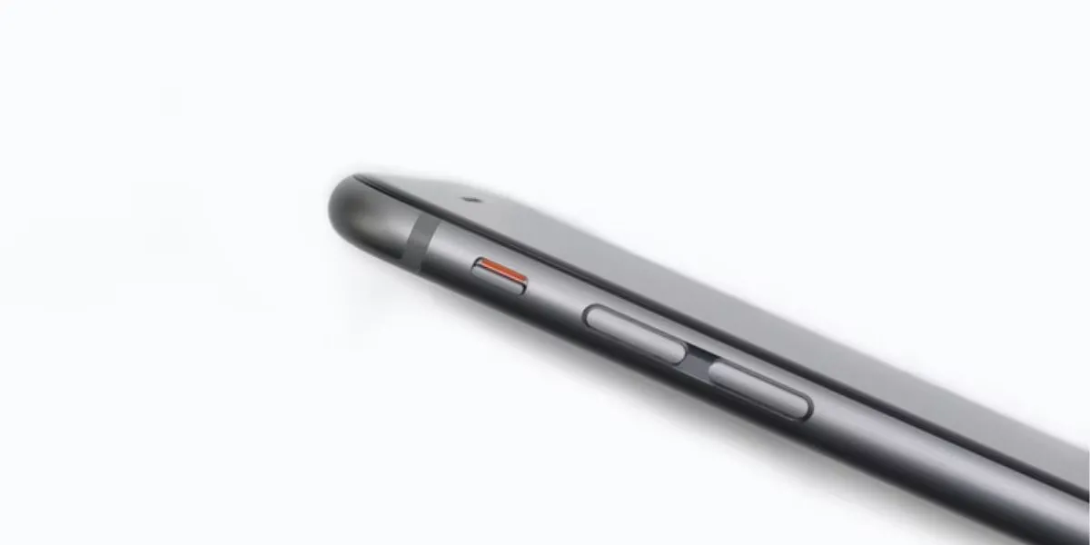 Nút gạt im lặng và các nút âm lượng trên cạnh iPhone, minh họa cách bật chế độ im lặng để tắt âm thanh sạc mặc định.