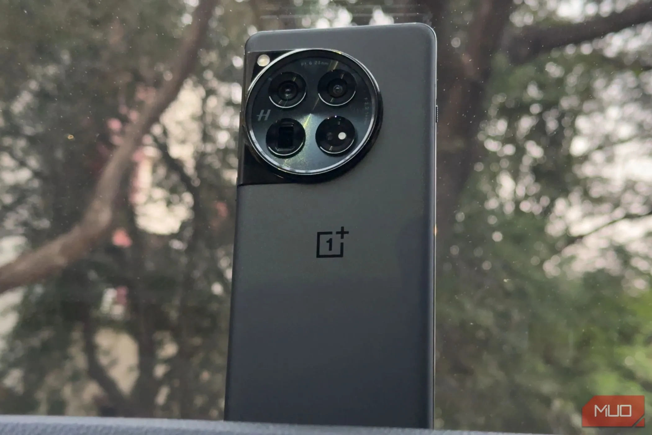 OnePlus 12 màu đen đặt trên bảng điều khiển ô tô, thể hiện sự sang trọng