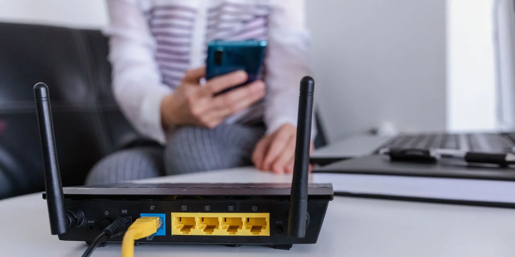 Router Wi-Fi trên bàn với người dùng ở hậu cảnh