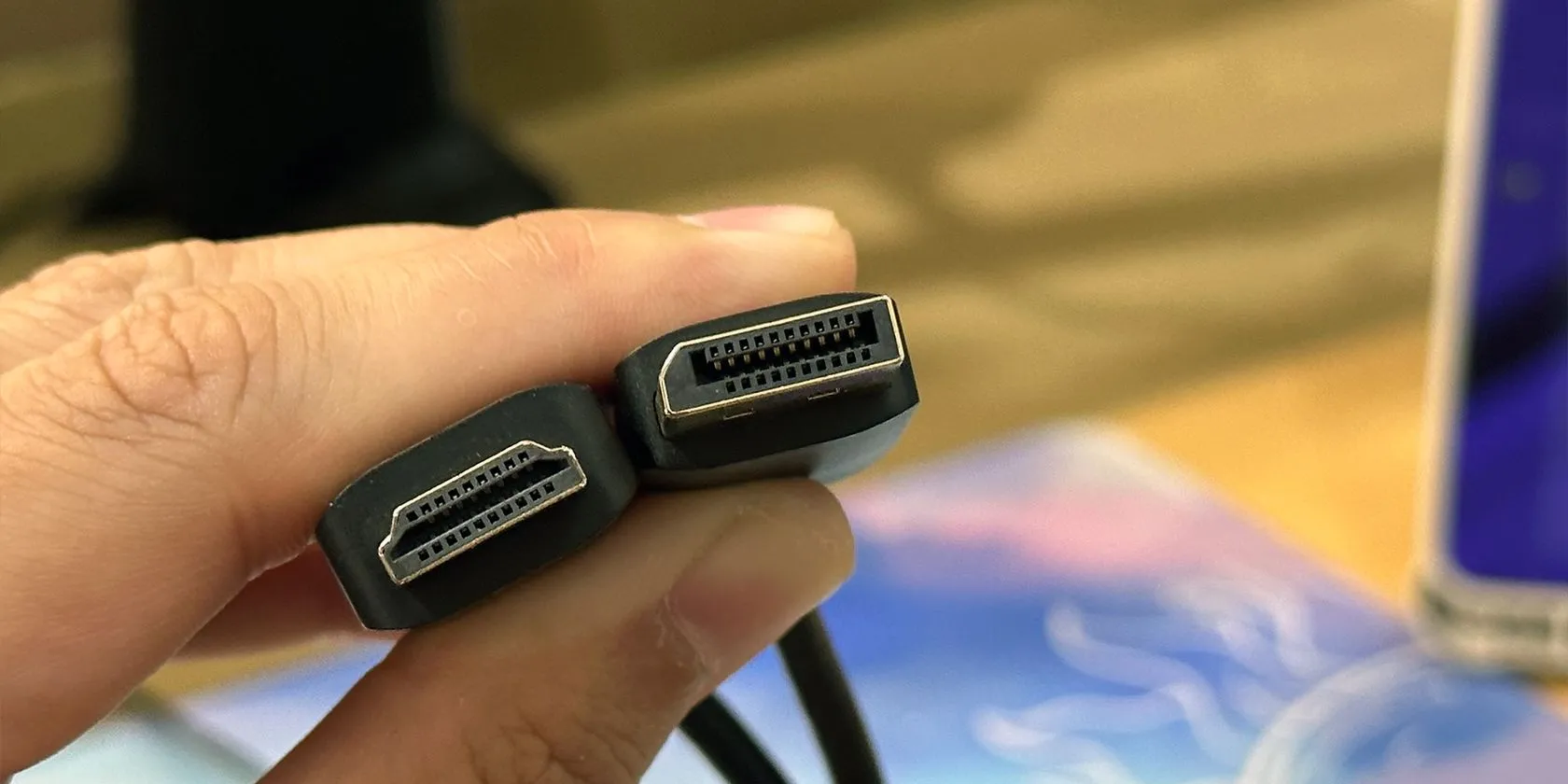 Sự khác biệt về hình dạng đầu cắm giữa cáp HDMI và DisplayPort, minh họa hai chuẩn kết nối video chính, với DisplayPort thường được ưu tiên cho gaming PC và màn hình tần số quét cao để tối ưu chất lượng hình ảnh.